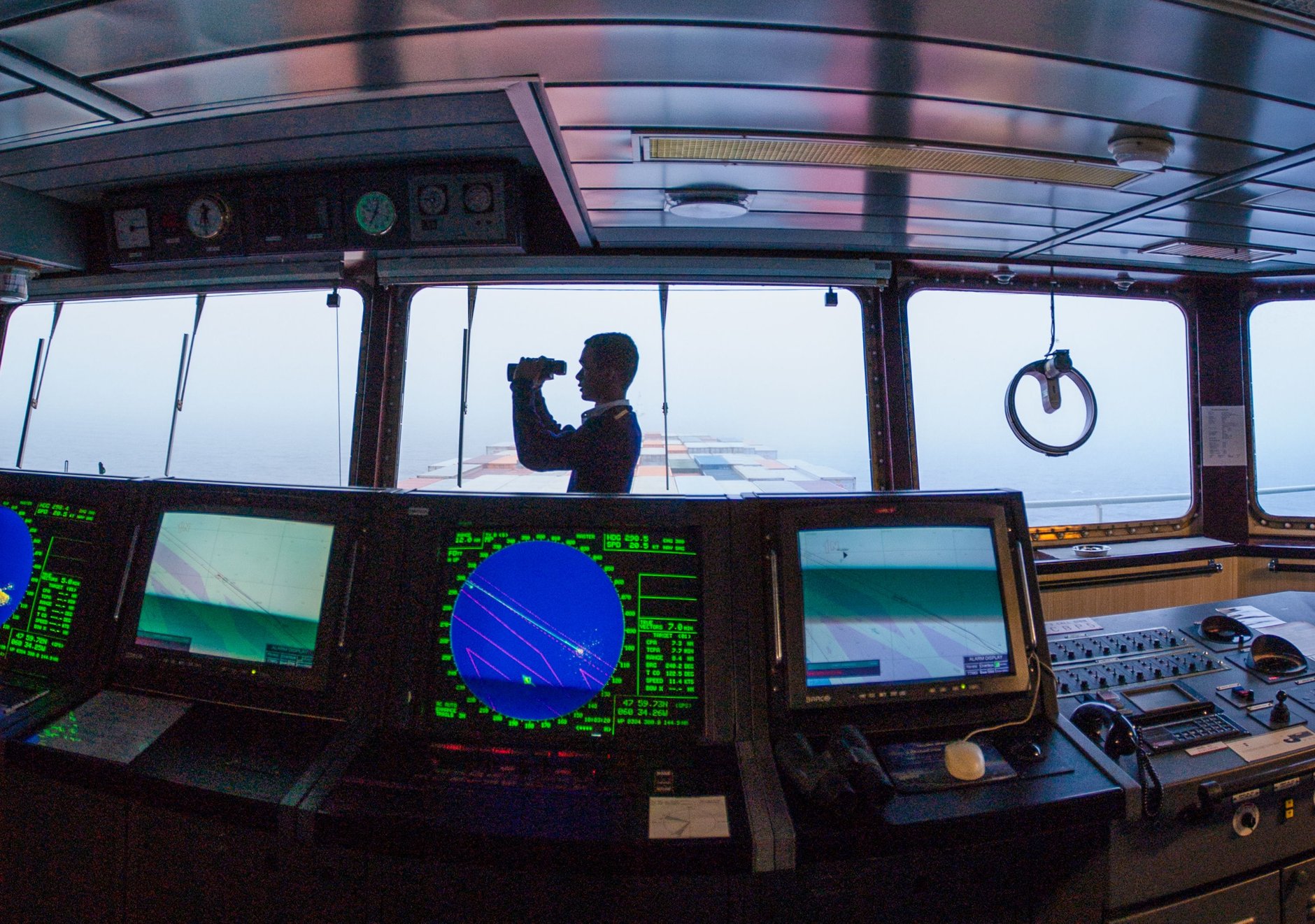 Workboat bridge at night with navigation displays during a dark coastal transit