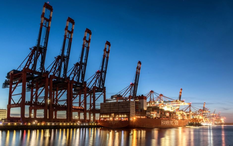 Container terminal at night with stacked containers and cranes